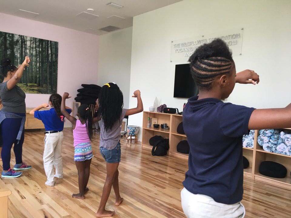 Young children learning dance poses with Teaching Artist