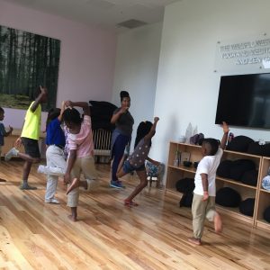 Young boys and girls actively learning choreography with teaching artist.